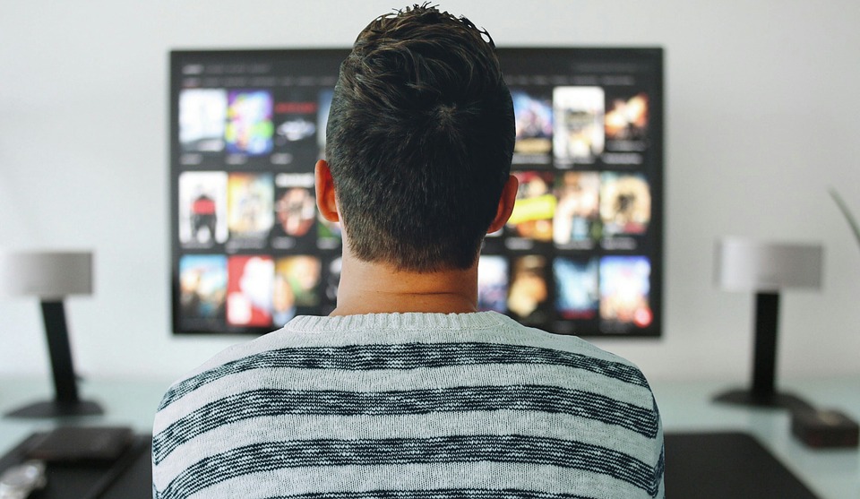 A photo of a man watching TV